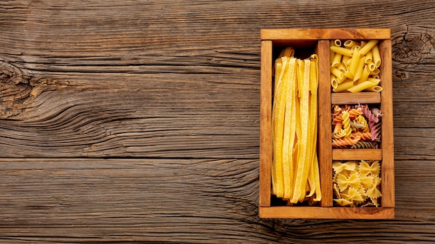 Pasta cruda in scatola di legno con spazio di copia