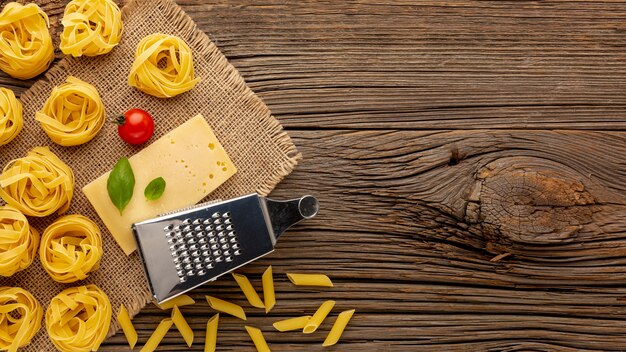 Uncooked penne and tagliatelle with hard cheese and copy space