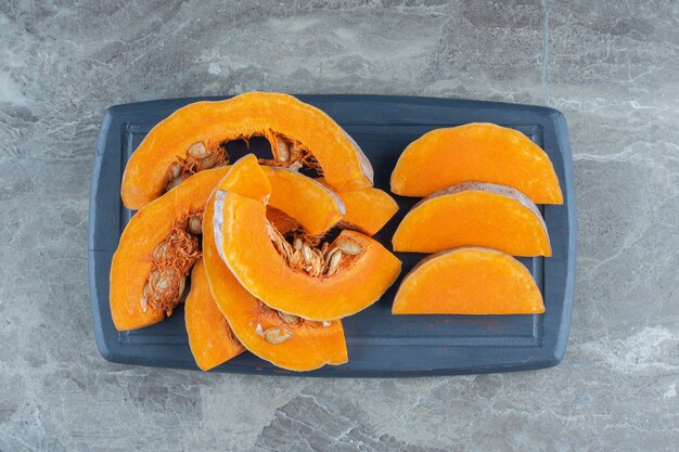 Uncooked pumpkin on the board , on the marble table. 