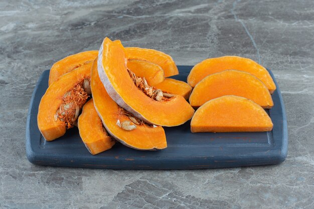 Uncooked pumpkin on the board , on the marble table. 