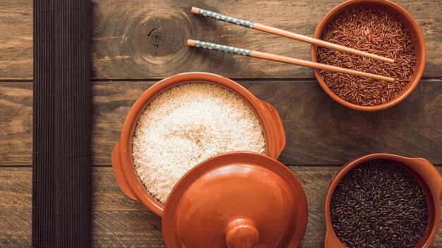 Размороженные чашки из зерна риса с палочками для еды на деревянном столе