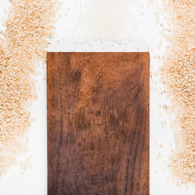 Free photo uncooked rice with wooden chopping board