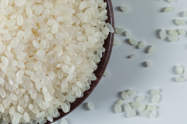 Free photo uncooked round rice in a bowl on white background