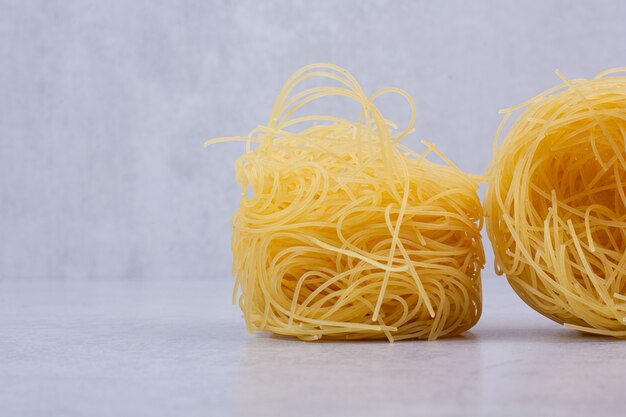 Uncooked spaghetti nests on stone surface