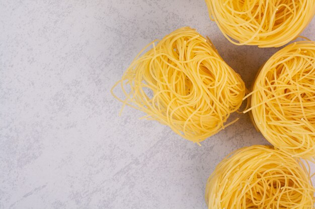 Uncooked spaghetti nests on stone surface