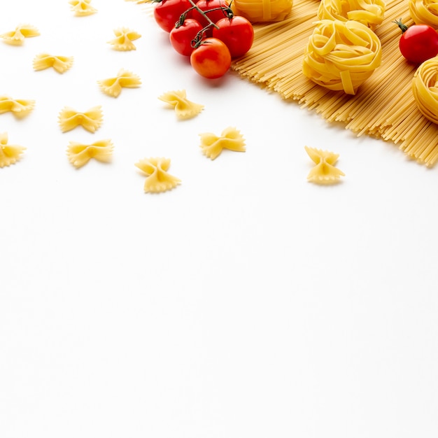 무료 사진 생 쌀된 스파게티 tagliatelle farfalle 및 복사 공간 토마토