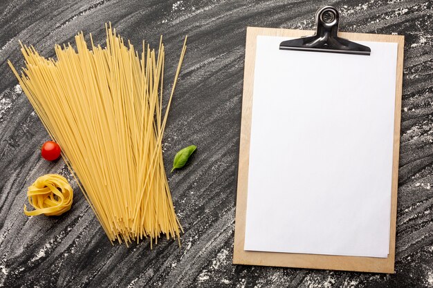 Uncooked spaghetti and tagliatelle with clipboard mock-up