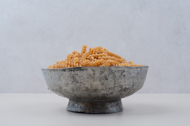 Uncooked spiral macaroni in classic bowl.