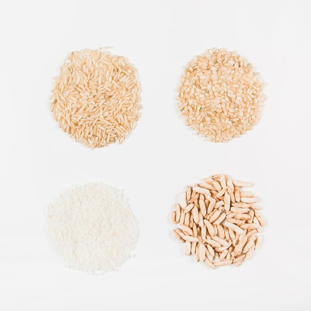 Uncooked white; brown and puffed rice isolated on white backdrop