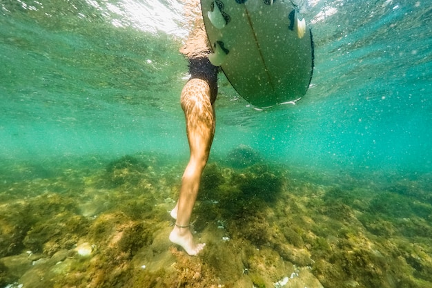 Foto gratuita colpo subacqueo di donna con tavola da surf