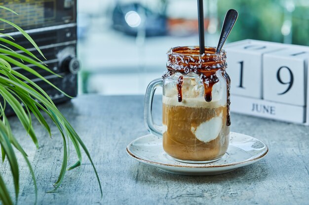 Unfinished milkshake with chocolate on mug with spoon 