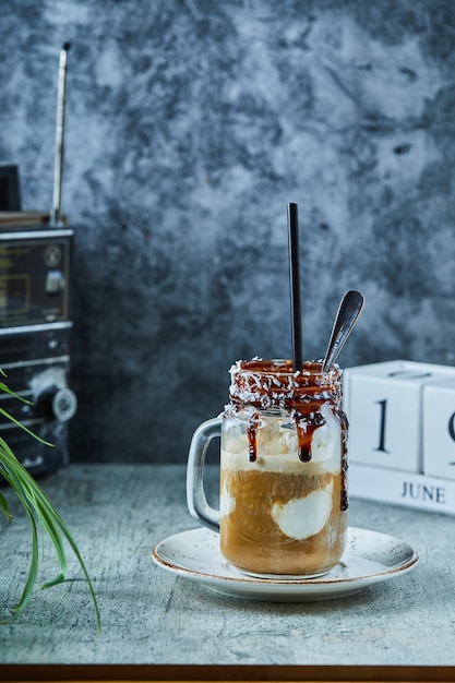 Unfinished milkshake with chocolate on mug with spoon 