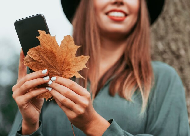 Unfocused smiley woman holding a leaf