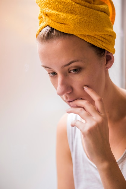 Unhappy Depressed Woman. Sad woman looking the rain falling through a window at home or hotel