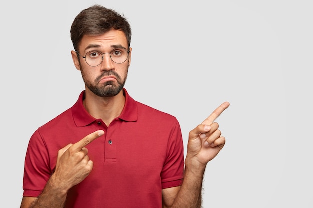 Free photo unhappy european young man frowns face in displeasure