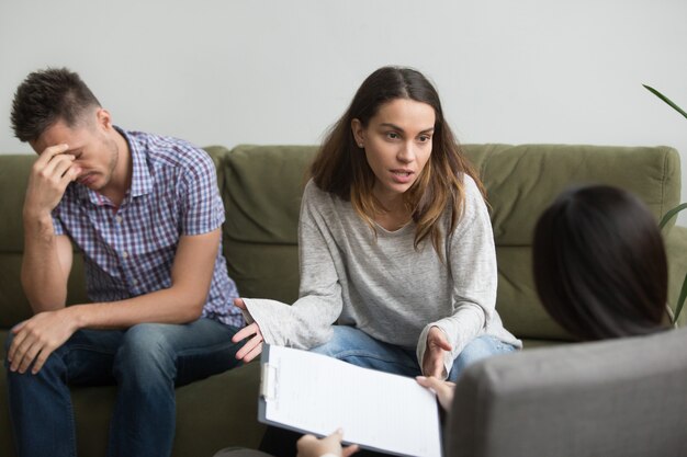 Unhappy frustrated woman sharing problems with counselor, couple counseling concept