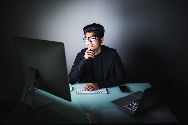 Несчастный индийский программист смотрит на экран компьютера
