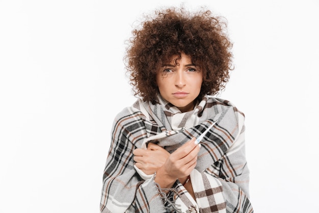 Free photo unhappy sick woman standing wrapped in a blanket