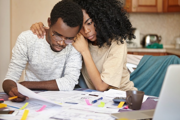 Unhappy young African couple facing financial stress