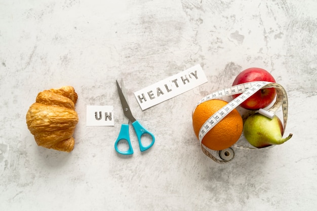 Unhealthy word and scissor with food showing healthy and unhealthy concept