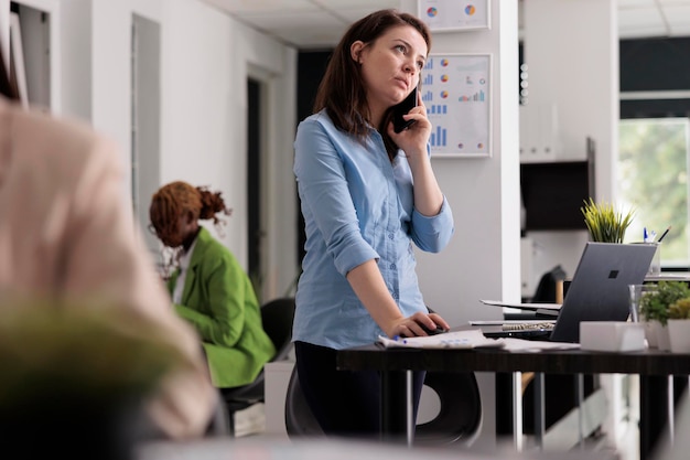 Unicorn business company office manager discussing management strategy with colleague on smartphone. Employee having mobile phone call about start up project research result