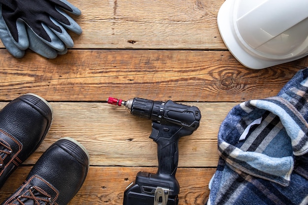 Free photo uniform and construction tools on wooden table top view