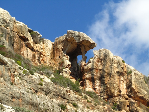 Unique natural rock shade formation at the cliff of Wied Babu Valley in Malta on blue sky
