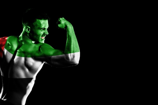 Free photo united arab emirates flag on handsome young muscular man black background