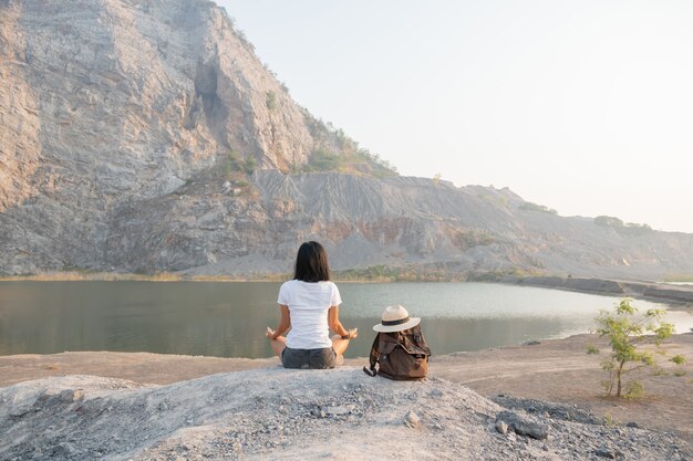 Единение с природой. молодая женщина занимается медитацией на открытом воздухе у озера