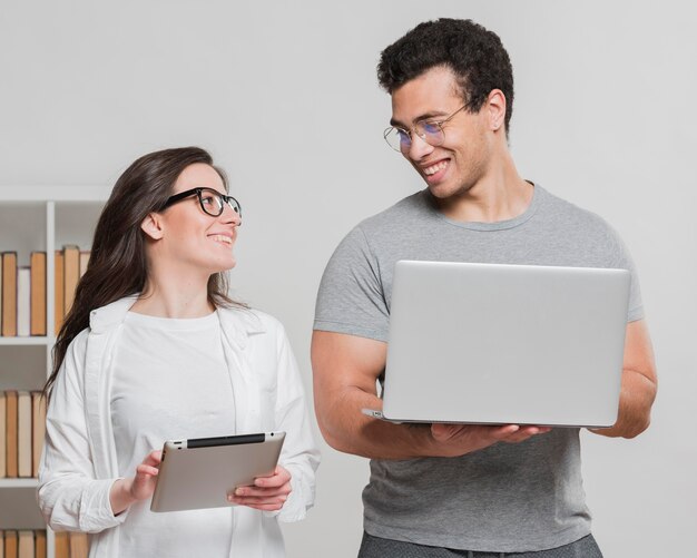 University classmates holding digital devices