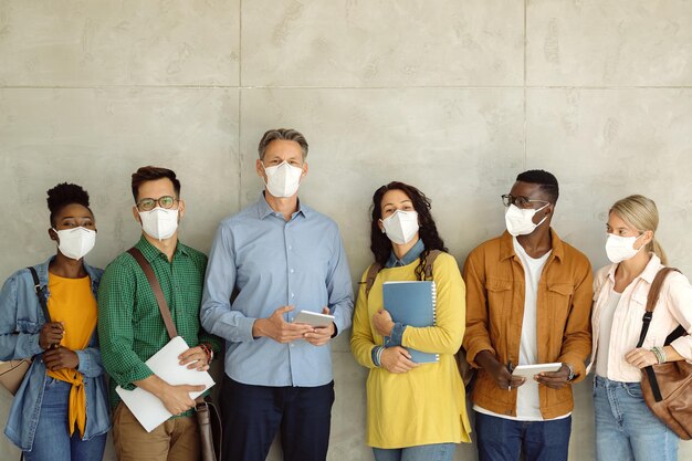 University professor and students with protective face masks against the wall