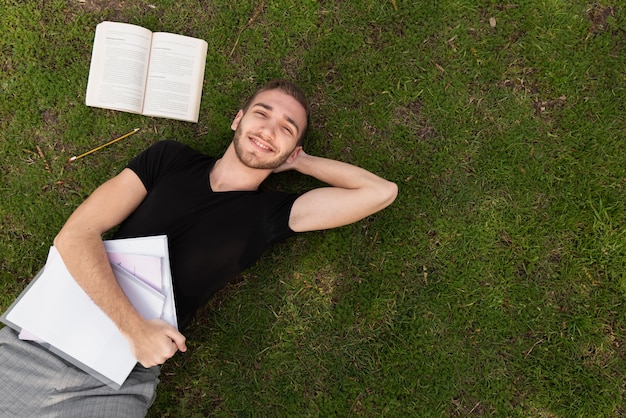 Студент университета отдыхает на траве