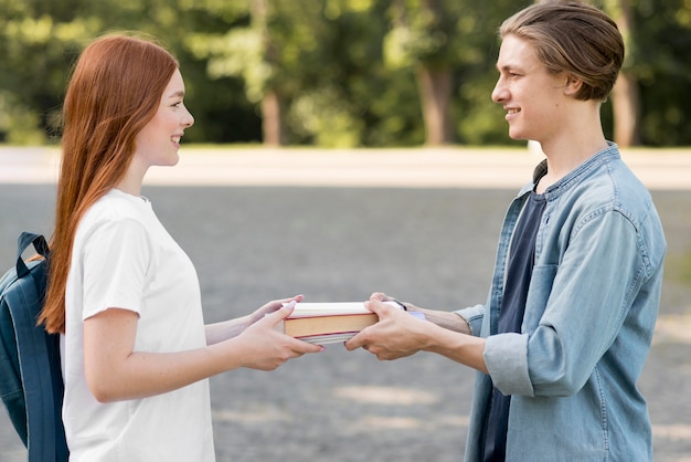 Foto gratuita studenti universitari che scambiano libro