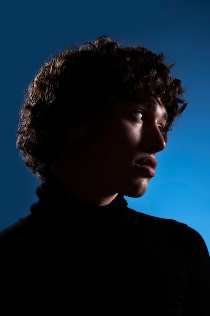 Free photo unknown man posing with blue background side view