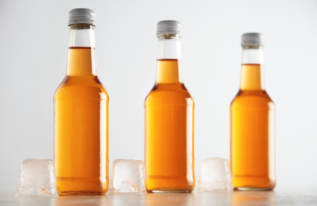 Free photo unlabeled rustic bottles sealed with tasty cold drink inside presented next big ice cubes