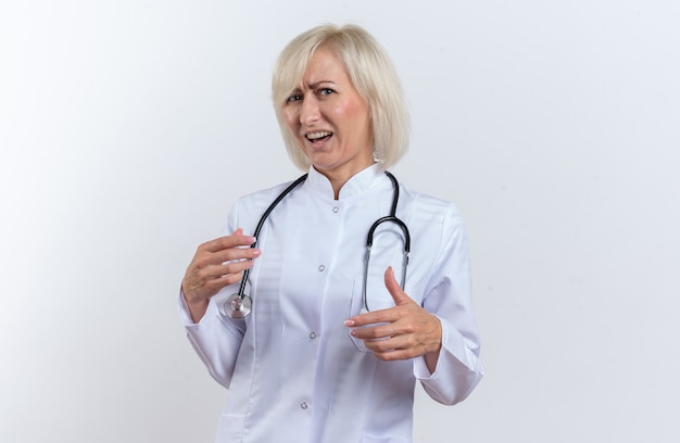 Unpleased adult slavic female doctor in medical robe with stethoscope looking at camera isolated on white background with copy space