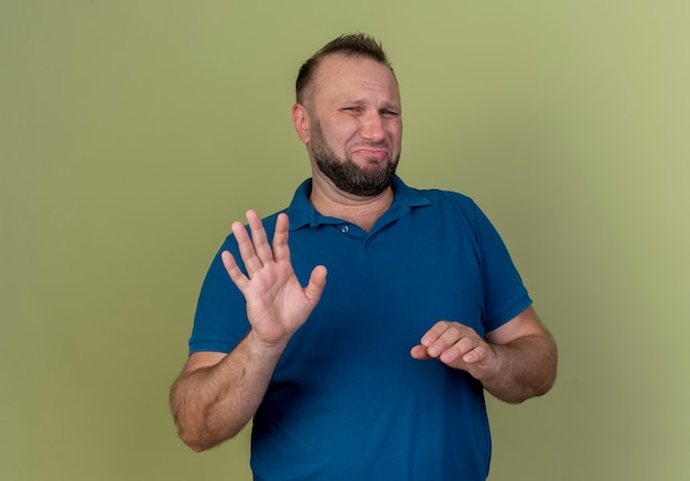 Unpleased adult slavic man keeping hand in air and doing no gesture 