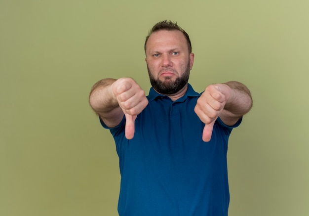 Free photo unpleased adult slavic man showing thumbs down