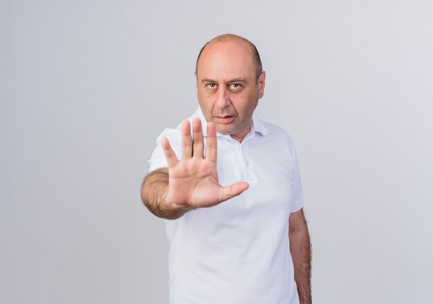 Unpleased casual mature businessman doing stop gesture at camera isolated on white background with copy space