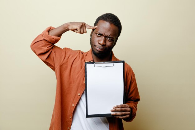 Unpleased putting finger on forehead young african american male holding clipboard isolated on white background