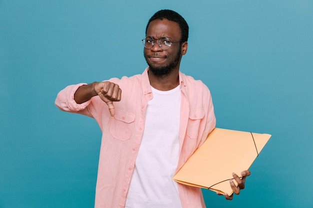 Unpleased showing thumbs down holding folder young africanamerican guy isolated on blue background