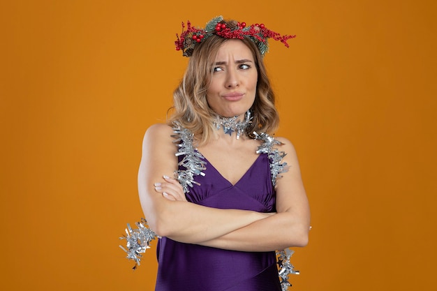 Free photo unpleased young beautiful girl wearing purple dress with wreath crossing hands isolated on brown background