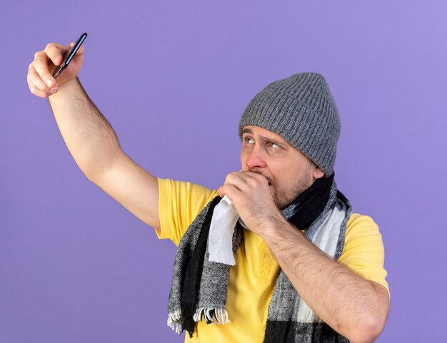 Unpleased young blonde ill slavic man wearing winter hat