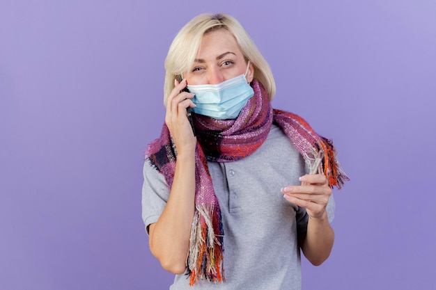 Unpleased young blonde ill slavic woman wearing medical mask and scarf