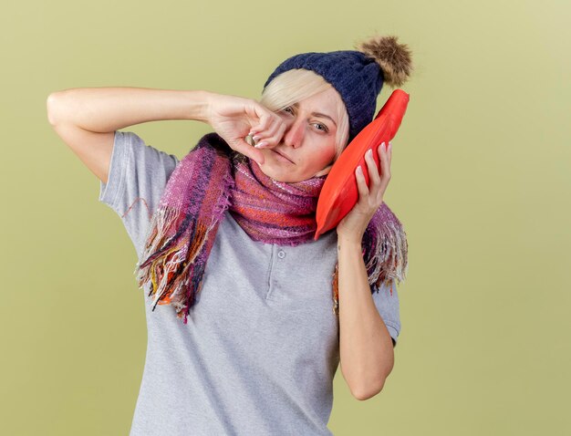 Unpleased young blonde ill slavic woman wearing winter hat