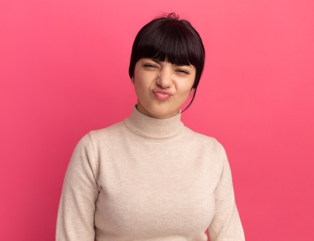 Free photo unpleased young brunette caucasian girl looks at camera