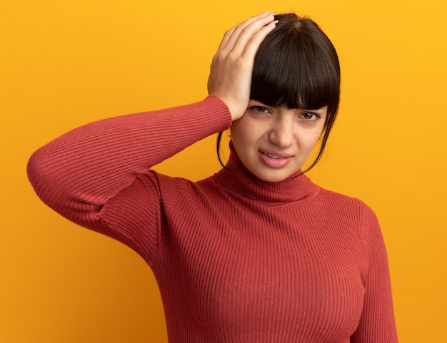 Free photo unpleased young brunette caucasian girl puts hand on head