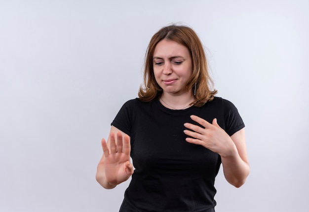 Недовольная молодая случайная женщина, не делающая жестов с рукой на груди на изолированной белой стене с копией пространства
