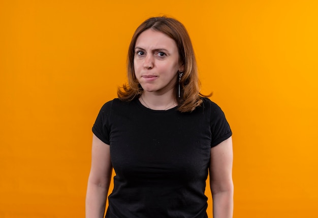 Unpleased young casual woman on isolated orange wall with copy space