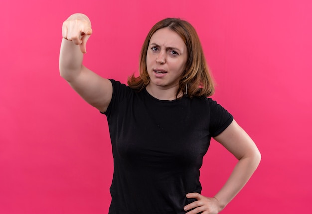 Giovane donna casuale dispiaciuta che indica con la mano sulla vita sulla parete rosa isolata